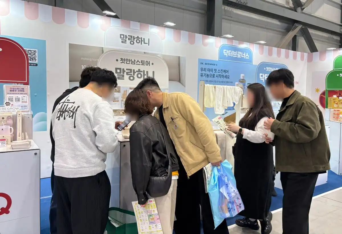 첫만남스토어 브랜드 부스에서 제품을 보는 방문객