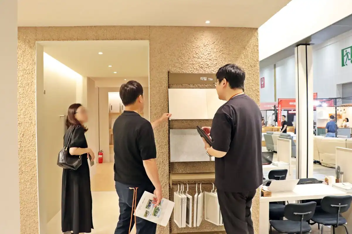 인테리어 마감재를 펼쳐놓고 상담하는 부스