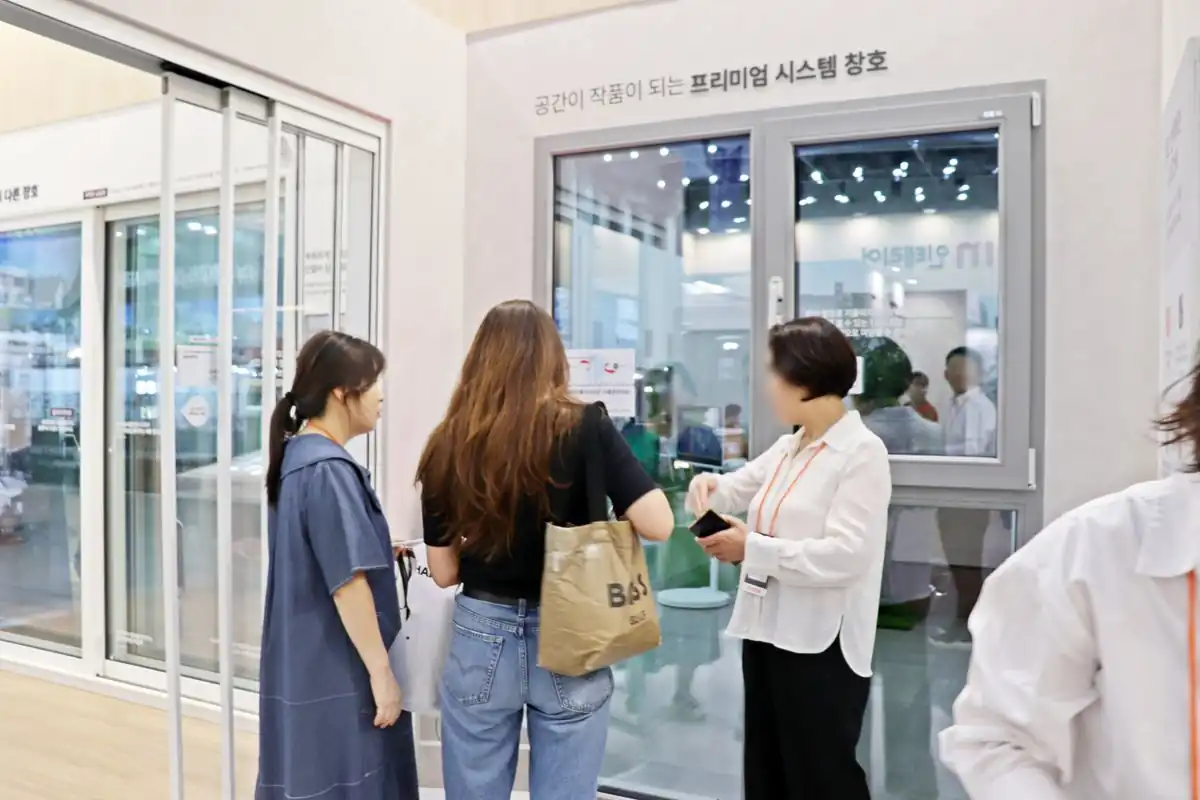 시스템 창호를 열어보며 설명 듣는 방문객