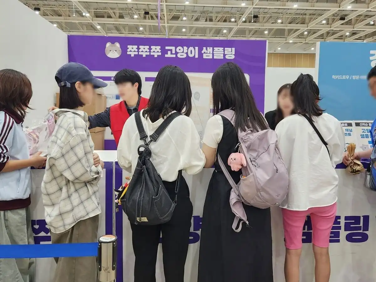 케이펫페어 샘플링 부스에서 샘플을 받는 방문객들