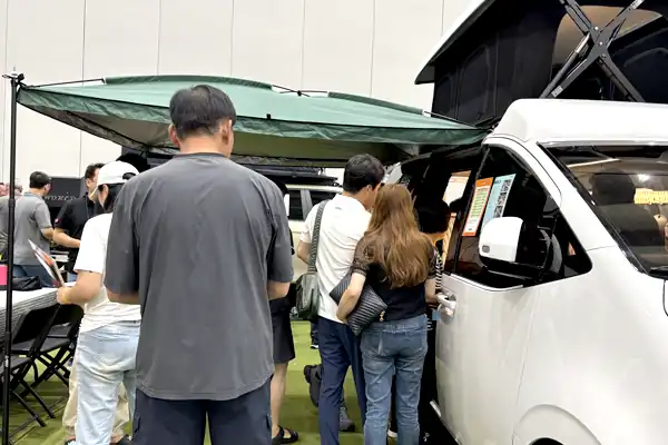 사이드어닝을 펼친 차량 앞의 관람객
